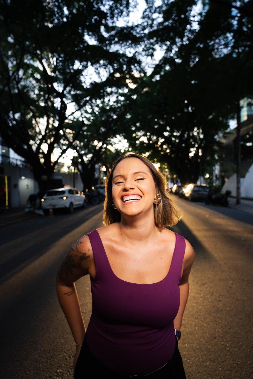 Rafa Campelo rindo numa rua arborizada de Recife